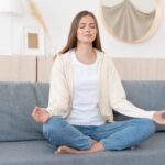 Woman sitting on couch meditating