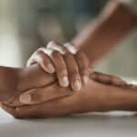 Two women holding hands.