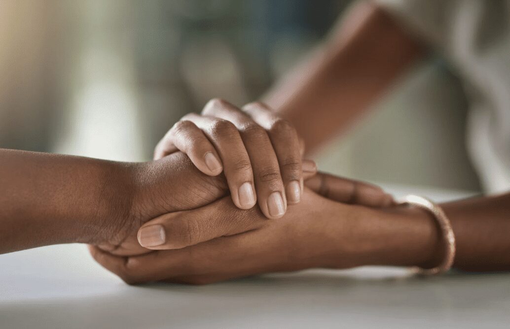 Two women holding hands.