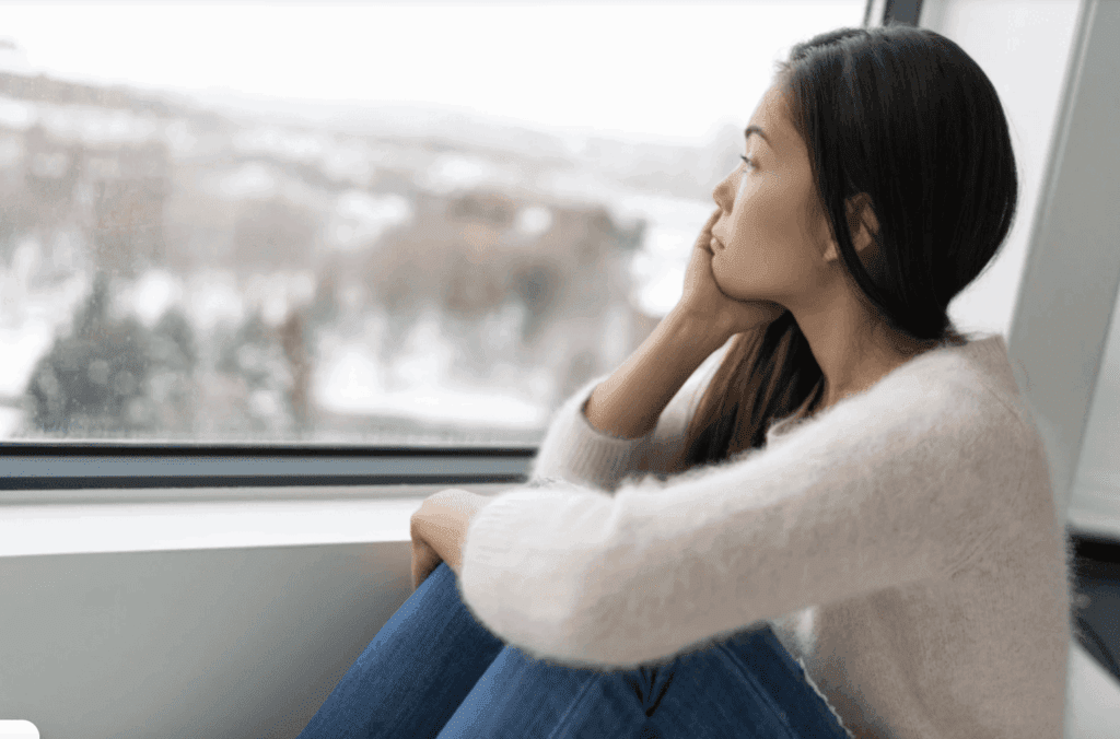 A woman looking outside at a winter day.