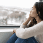 A woman looking outside at a winter day.